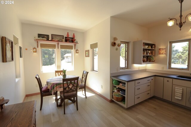 dining space featuring sink, a chandelier, and hardwood / wood-style flooring