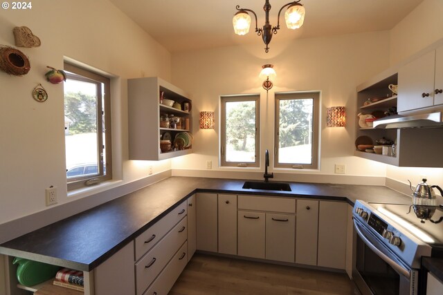 kitchen with dark hardwood / wood-style flooring, stainless steel range with electric cooktop, sink, and a wealth of natural light