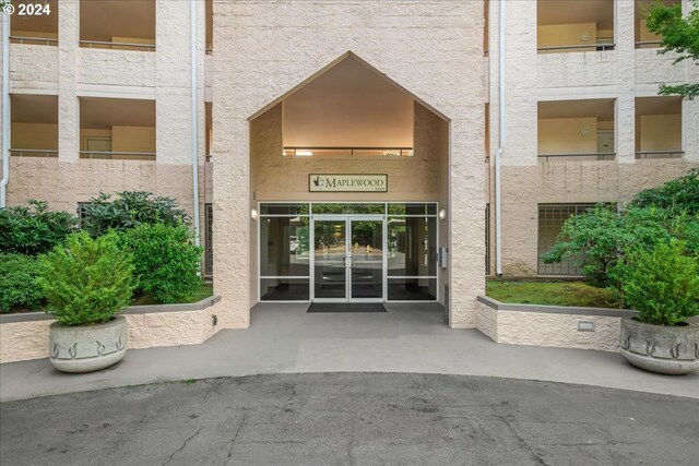 property entrance featuring a balcony and french doors