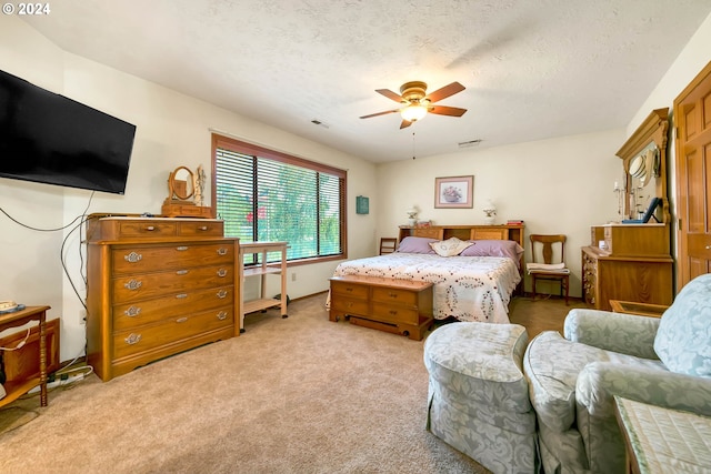 carpeted bedroom featuring a textured ceiling and ceiling fan