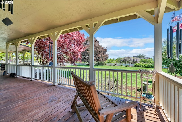 wooden terrace featuring a yard