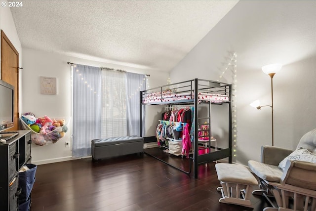 bedroom featuring a textured ceiling, vaulted ceiling, and dark hardwood / wood-style floors