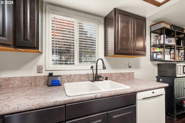 kitchen featuring dishwasher, sink, and dark brown cabinets