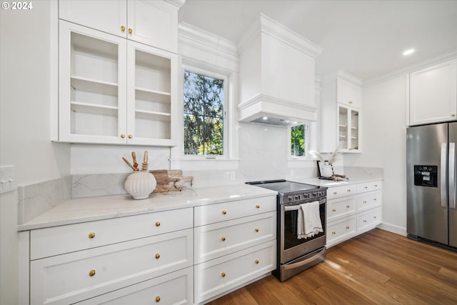 kitchen with light stone countertops, custom exhaust hood, stainless steel appliances, dark hardwood / wood-style floors, and white cabinetry