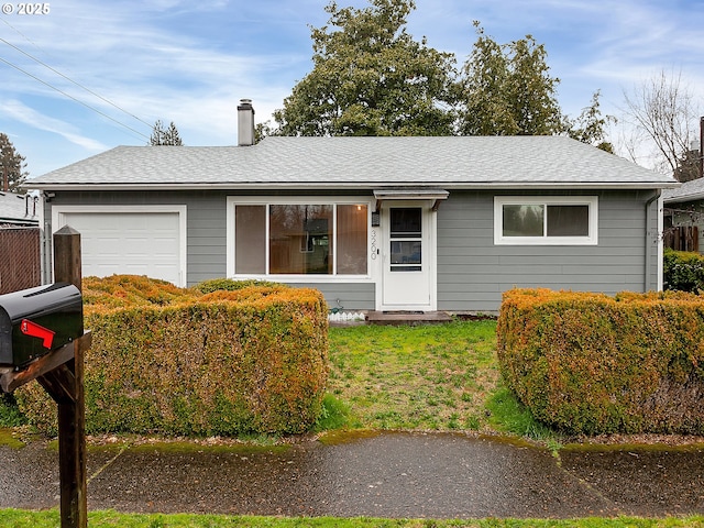 ranch-style home with a chimney, a garage, a front lawn, and a shingled roof
