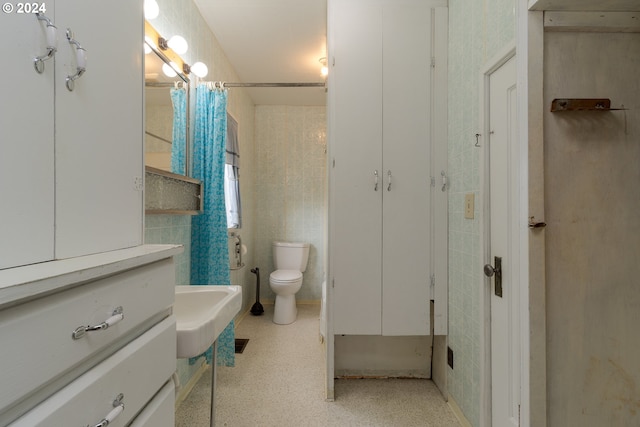 bathroom featuring curtained shower, sink, and toilet