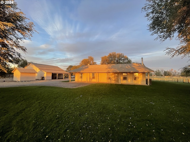 back house at dusk featuring a yard