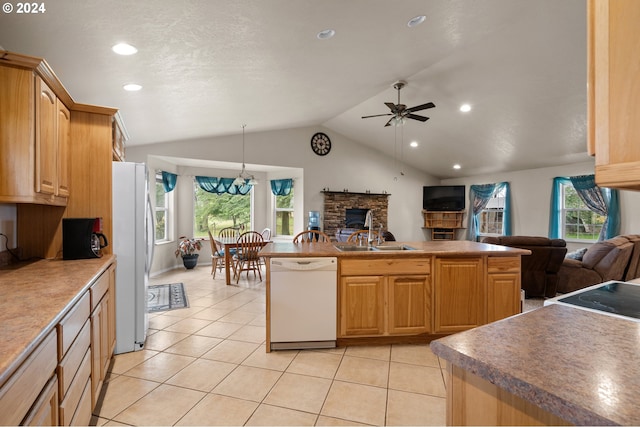 kitchen featuring white appliances, light brown cabinets, vaulted ceiling, and sink