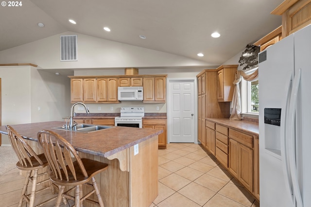 kitchen with an island with sink, white appliances, sink, vaulted ceiling, and light tile patterned floors