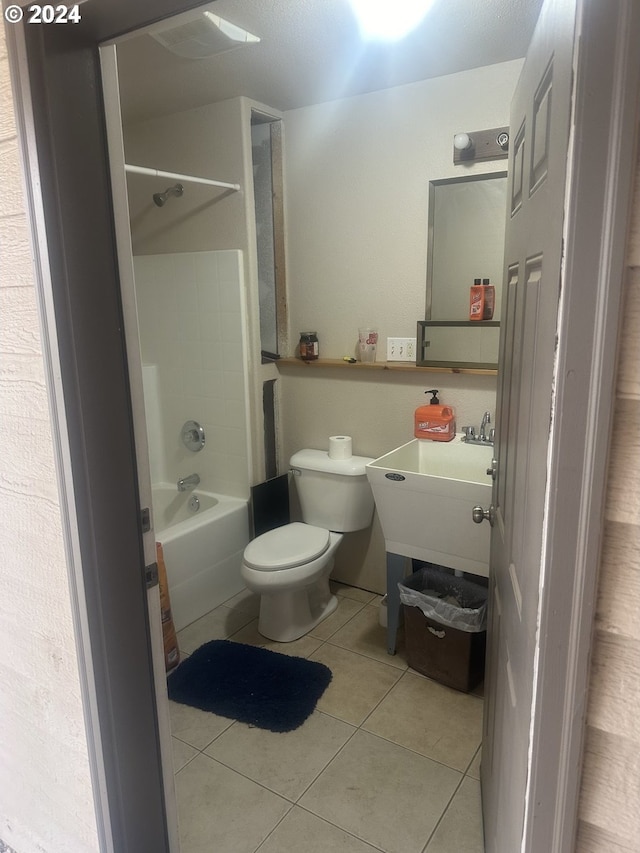 bathroom featuring tub / shower combination, tile patterned flooring, and toilet