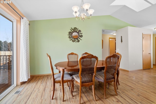 dining room featuring light hardwood / wood-style flooring, a chandelier, and lofted ceiling