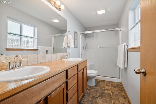 bathroom with vanity, toilet, and a shower with shower door