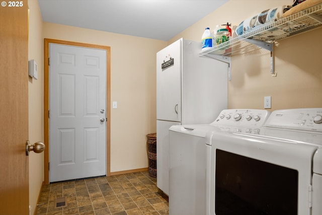 washroom with washer and dryer and cabinets