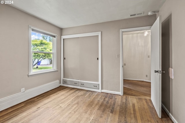 unfurnished bedroom featuring light hardwood / wood-style floors and a closet