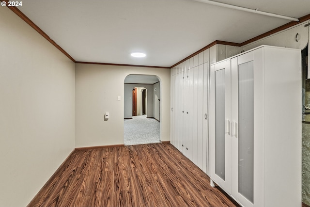 hallway with wood-type flooring and ornamental molding