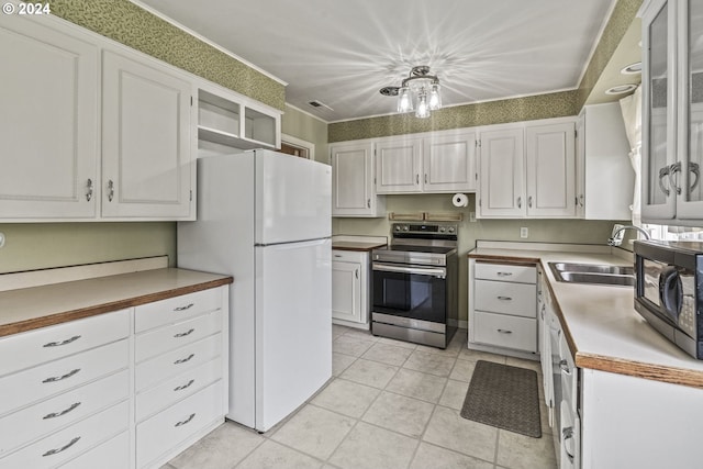 kitchen with electric stove, sink, white cabinets, and white refrigerator