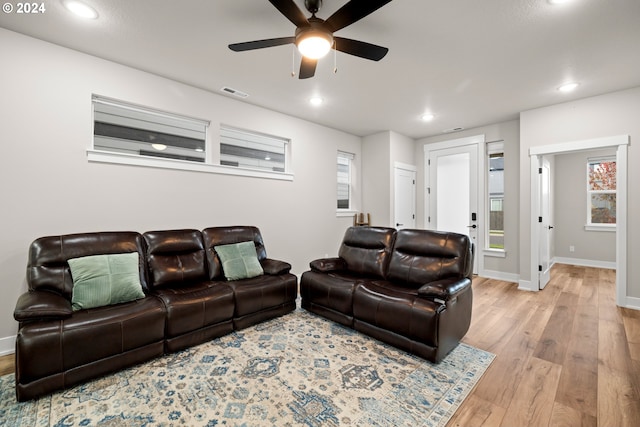 living room with light hardwood / wood-style floors and ceiling fan