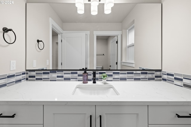 bathroom with vanity and decorative backsplash