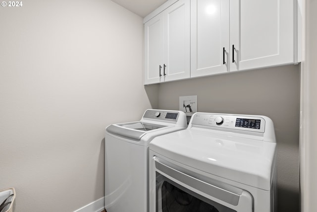 laundry area featuring washer and dryer and cabinets