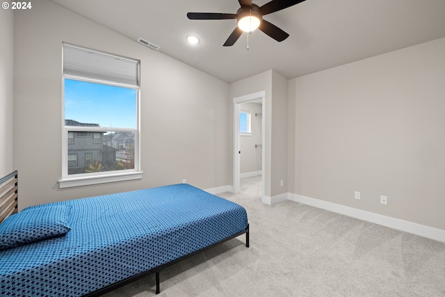 bedroom with light colored carpet, vaulted ceiling, and ceiling fan