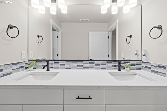 bathroom with vanity and tasteful backsplash