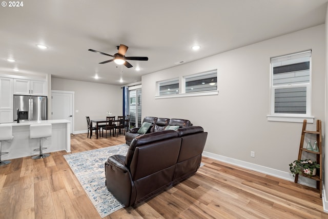 living room with light hardwood / wood-style floors and ceiling fan