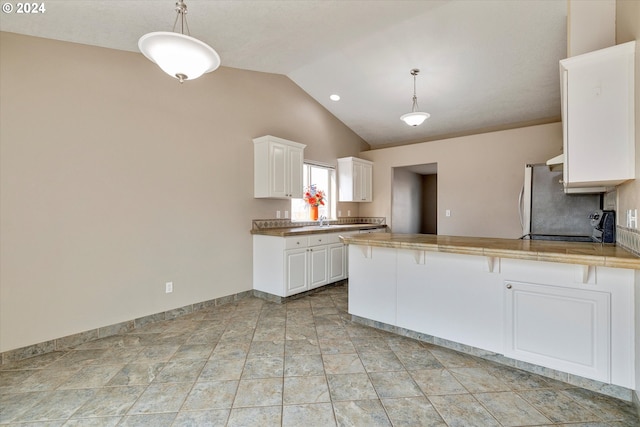 kitchen featuring kitchen peninsula, white cabinetry, hanging light fixtures, and lofted ceiling