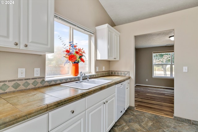 kitchen featuring white cabinetry, tile countertops, white dishwasher, and sink