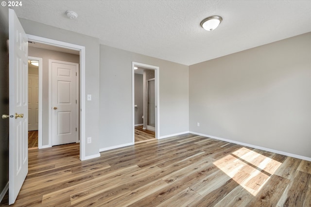 unfurnished bedroom featuring hardwood / wood-style flooring and a textured ceiling