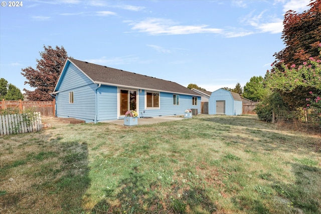 back of property featuring a patio area, an outdoor structure, a lawn, and a garage