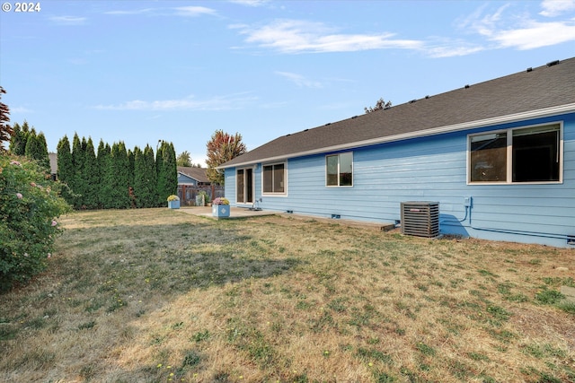 rear view of house with a yard and central AC unit