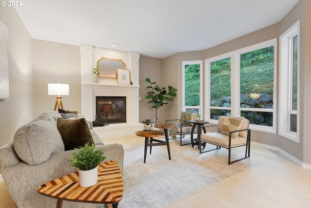 living room featuring baseboards, a brick fireplace, and light colored carpet