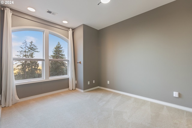 unfurnished room with baseboards, recessed lighting, visible vents, and light colored carpet