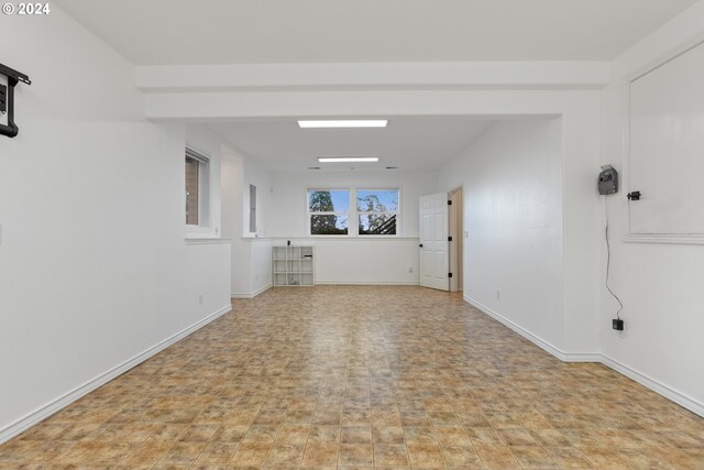 unfurnished room with baseboards