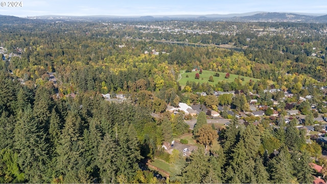 birds eye view of property with a wooded view and a mountain view