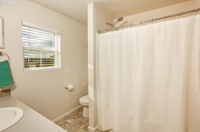 bathroom featuring vanity, toilet, and walk in shower