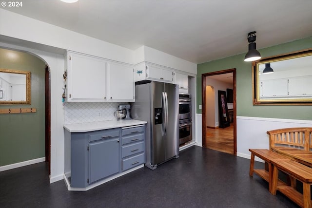 kitchen featuring decorative backsplash, decorative light fixtures, appliances with stainless steel finishes, and white cabinetry