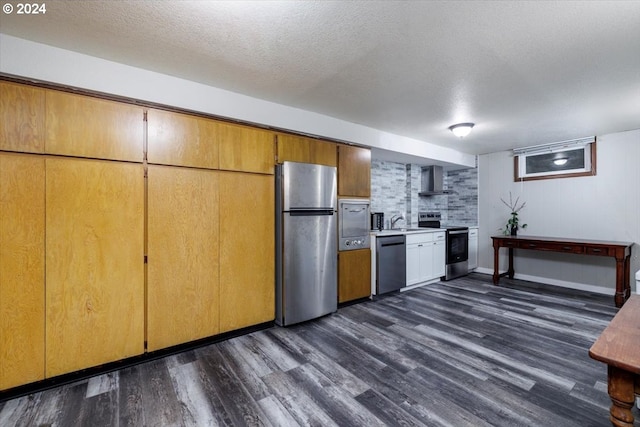 kitchen with appliances with stainless steel finishes, wall chimney exhaust hood, dark wood-type flooring, and a textured ceiling