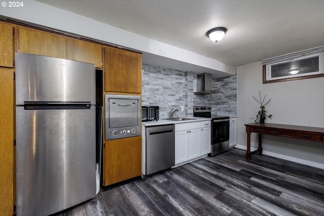 kitchen with appliances with stainless steel finishes, wall chimney range hood, white cabinetry, and dark hardwood / wood-style floors