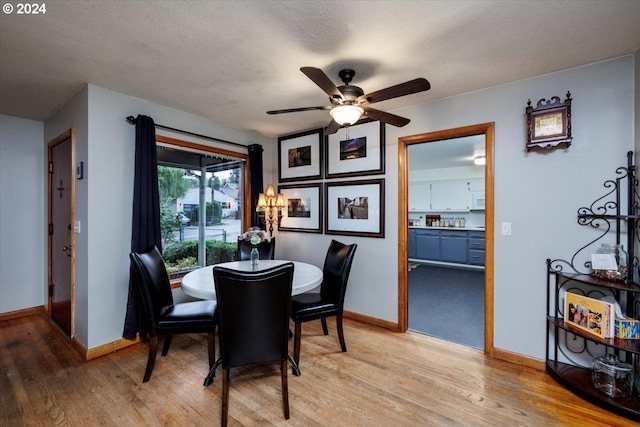 dining room with ceiling fan, a textured ceiling, and light hardwood / wood-style flooring