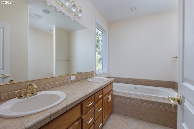 bathroom featuring tile patterned floors, vanity, and tiled bath