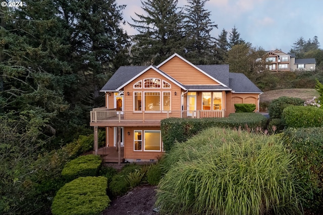 back house at dusk featuring a balcony