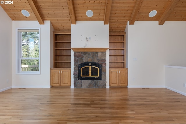 unfurnished living room with lofted ceiling with beams, hardwood / wood-style flooring, a stone fireplace, and wooden ceiling