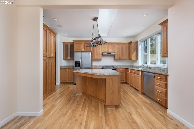 kitchen featuring a center island, light hardwood / wood-style flooring, stone countertops, and appliances with stainless steel finishes