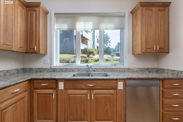 kitchen with light stone countertops, sink, and stainless steel dishwasher