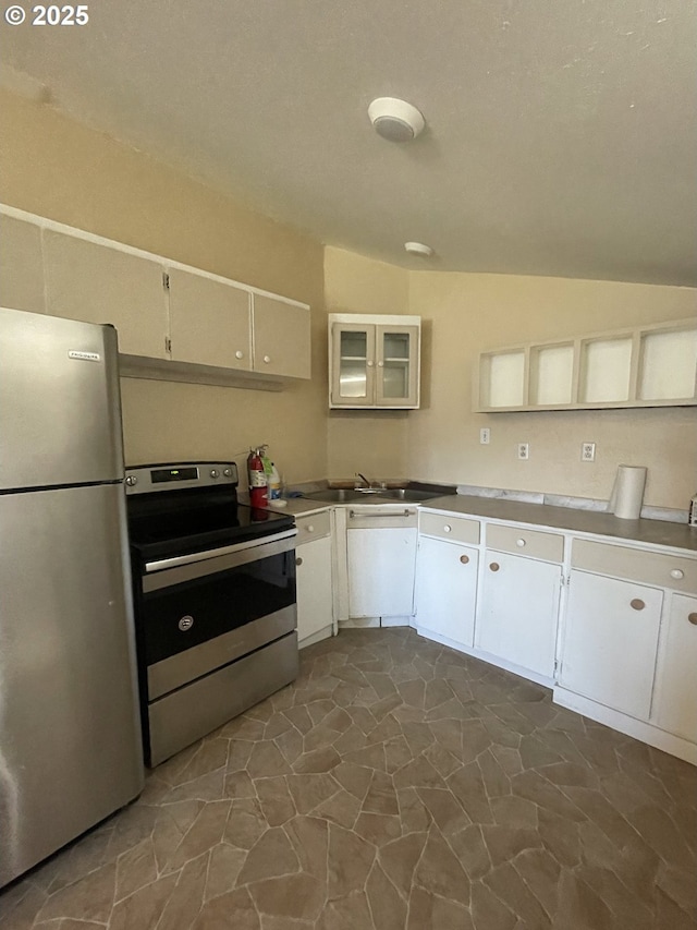 kitchen featuring white cabinets, stainless steel appliances, lofted ceiling, and sink