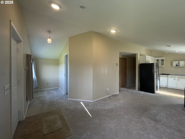 unfurnished room featuring lofted ceiling and carpet