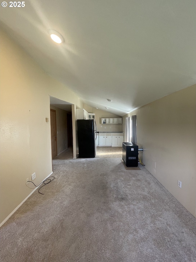 unfurnished living room featuring light colored carpet and lofted ceiling