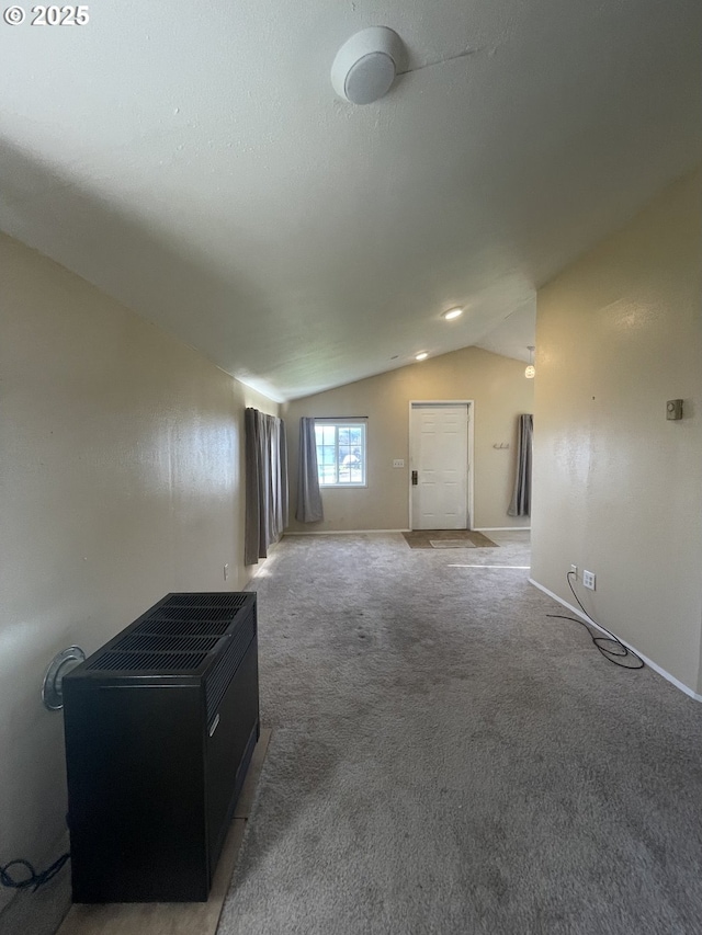 unfurnished room with vaulted ceiling and carpet