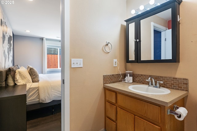 ensuite bathroom with vanity, ensuite bath, and tasteful backsplash